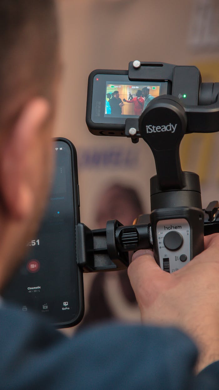 Man uses a smartphone stabilizer for filming, ensuring smooth footage with modern technology.